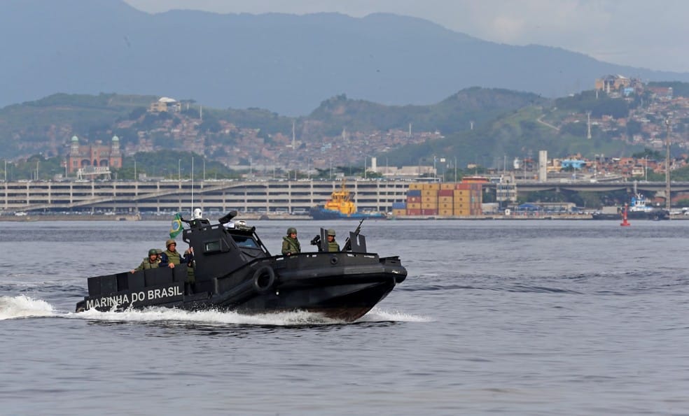 Marinha faz patulha na Baía de Guanabara. Uma lancha blindada com agentes passa e o Complexo do Alemão e castelo da Fiocruz ao fundo — Foto: Fabiano Rocha /Agência O GLOBO