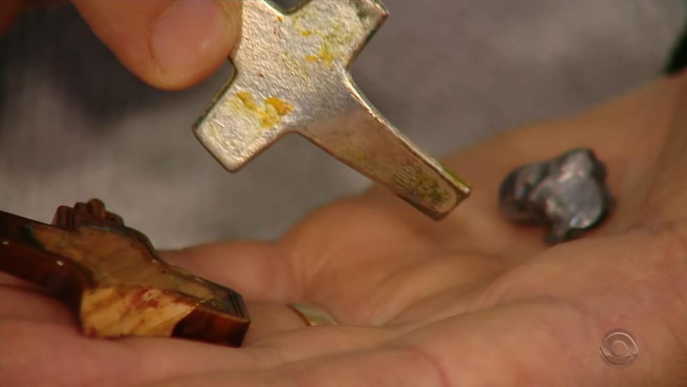 Crucifixo de metal amorteceu bala que atingiu padre durante assalto em Caxias do Sul — Foto: Reprodução/RBS TV