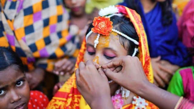 Menina sendo enfeitada para casamento em Bangladesh