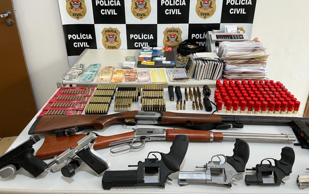 Armas, munições, dinheiro, documentos e máquina de contagem de notas apreendidas em Colina, SP — Foto: Divulgação/Polícia Civil de Colina