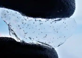 Cientista segura um pedaço de gelo perfurado na Antártica ocidental, mostrando as bolhas de ar presas dentro dele - Foto: University of Cambridge/British Antarctic Survey