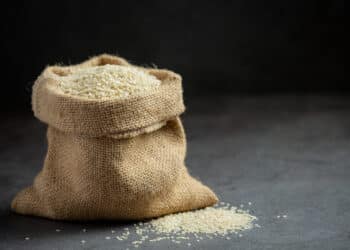 Sesame seeds in bag on dark background