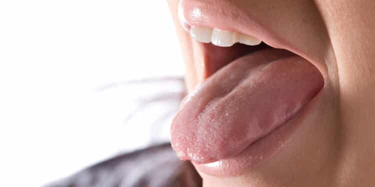 Closeup of a young woman sticking out her tongue.