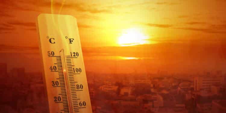 Thermometer with high temperature on the city with glowing sun background. Heatwave concept