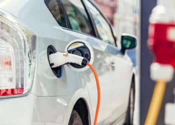 Power supply for electric car charging. Electric car charging station. Close up of the power supply plugged into an electric car being charged.