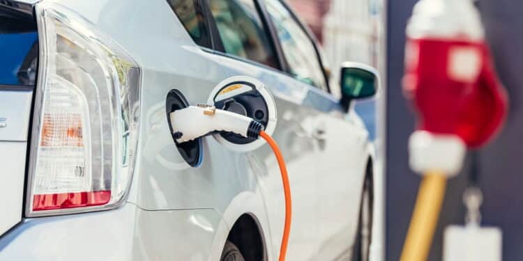 Power supply for electric car charging. Electric car charging station. Close up of the power supply plugged into an electric car being charged.