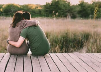 Couple in love embraced on their backs to reconcile and celebrate their love, sitting in nature.