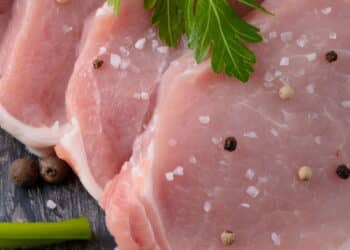 raw meat steak on dark wooden board with spices and salt