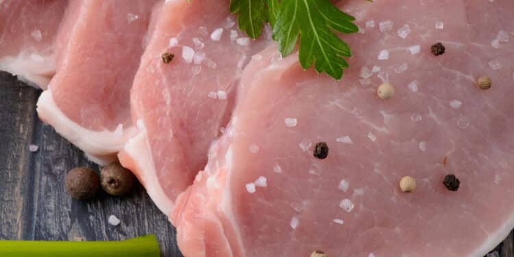 raw meat steak on dark wooden board with spices and salt