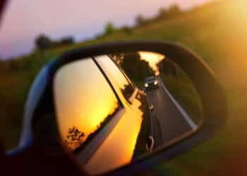 Driving at sunset - peek into a rear view mirror