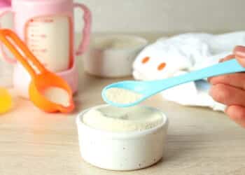 Concept of baby food with рowdered milk on wooden table