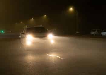 Road view of vehicles using the high beams in a foggy night