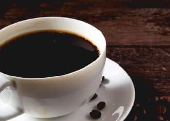 coffee cup and coffee beans on wooden table