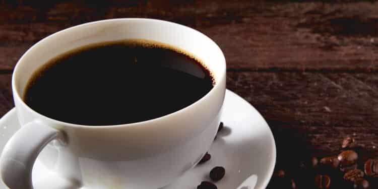 coffee cup and coffee beans on wooden table