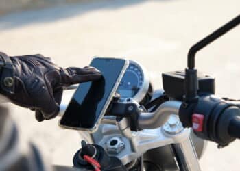 Unrecognizable person using cell phone on a motorcycle