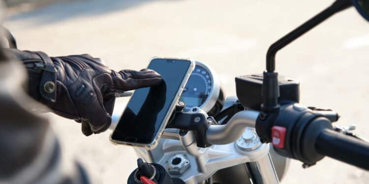 Unrecognizable person using cell phone on a motorcycle