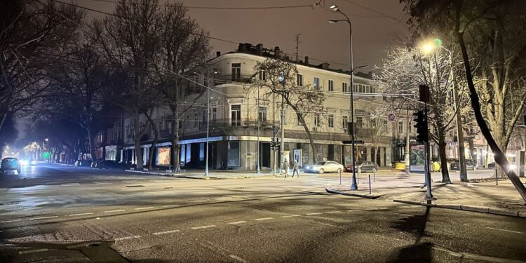 Odessa, Ukraine - 26 January 2023: Blackout in the Odessa Ukraine streets without street lighting only reflection color of traffic light and cars lights.