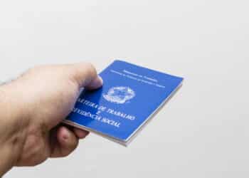 hands of middle-aged man holding work book, Brazilian social security document