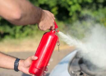 Man using car to extinguish a car fire