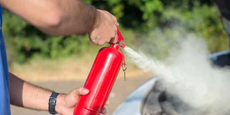 Man using car to extinguish a car fire