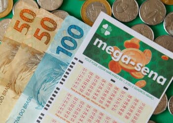 Minas Gerais, Brazil - February 22, 2021: cash notes, coins and lottery ticket Caixa Mega Sena