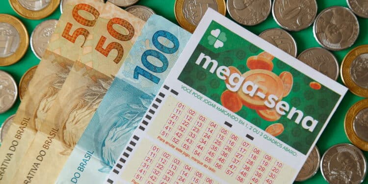 Minas Gerais, Brazil - February 22, 2021: cash notes, coins and lottery ticket Caixa Mega Sena