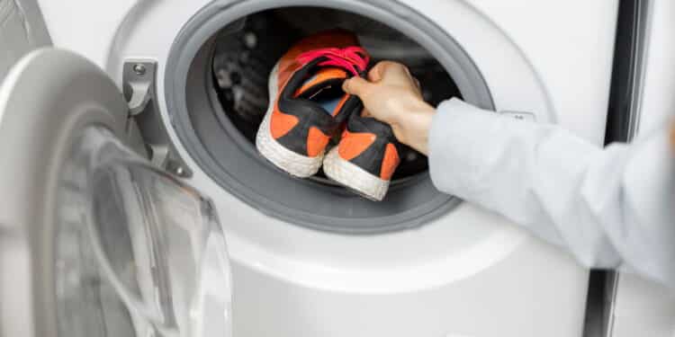 Dirty sport shoes on the drum of a washing machine