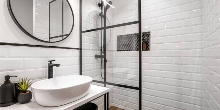 Simple bathroom with black shower, round mirror and classic white tiles.