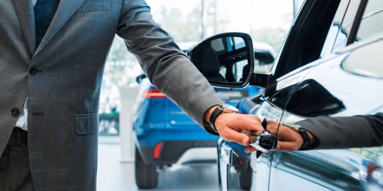 Homem abrindo porta do carro em concessionária - Créditos: depositphotos.com / VitalikRadko