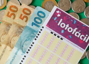 Minas Gerais, Brazil - February 22, 2021: cash notes, coins and lottery ticket Caixa Lotofacil