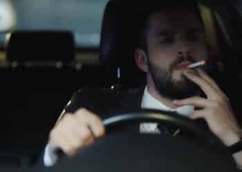 Homem fumando ao volante - Créditos: depositphotos.com / RostyslavOleksin