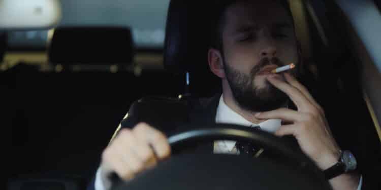 Homem fumando ao volante - Créditos: depositphotos.com / RostyslavOleksin