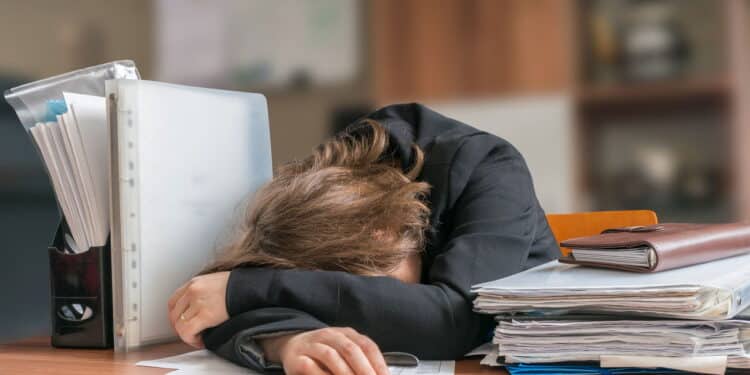 Lazy business woman sleeping on desk in office.