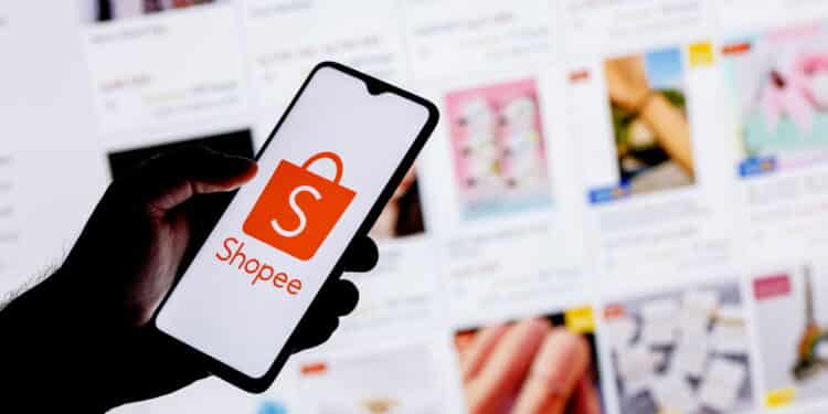 Kazan, Russia - Oct 14, 2021: Shopee is e-commerce technology company. A smartphone with the Etsy logo in a hand on background of the catalog from the site.