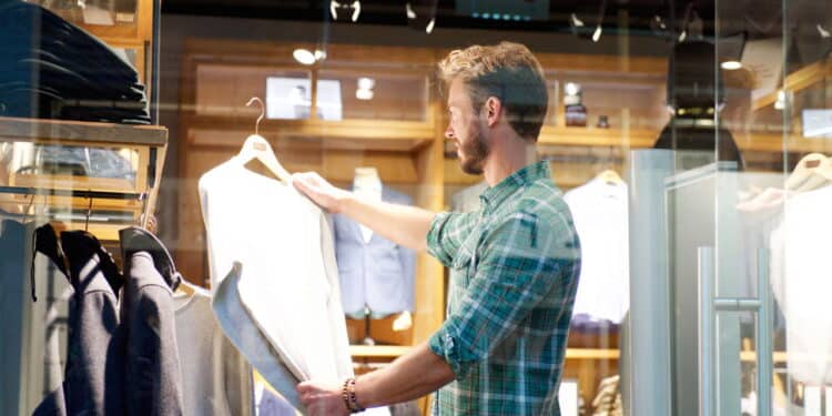 Imagem de homem comprando roupa em loja - Créditos: depositphotos.com / mimagephotos