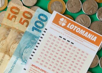 Minas Gerais, Brazil - February 22, 2021: cash notes, coins and lottery ticket Caixa Lotomania