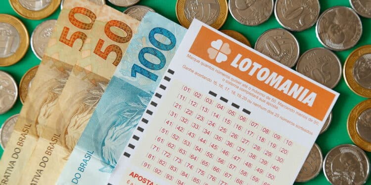 Minas Gerais, Brazil - February 22, 2021: cash notes, coins and lottery ticket Caixa Lotomania