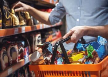 Cropped image of handsome man with a market basket doing shopping at the supermarket