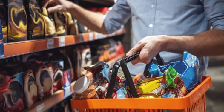 Cropped image of handsome man with a market basket doing shopping at the supermarket