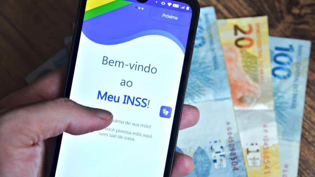 Meu INSS aplicativo e dinheiro ao fundo - Créditos: depositphotos.com / thenews2.com