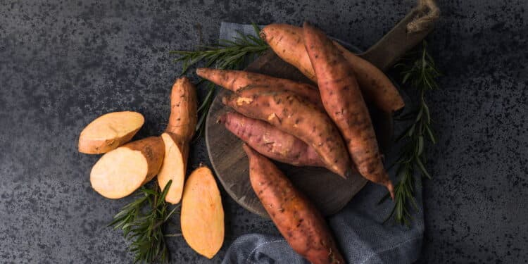 Batata-doce em fundo de tábua de madeira - Créditos: depositphotos.com / sokor