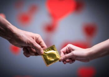 Imagem de pessoas segurando camisinha - Créditos: depositphotos.com / Deklofenak