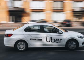 Ukraine, Kyiv - 16 July 2021: White Ford Falcon Taxi Uber car moving on the street. Editorial