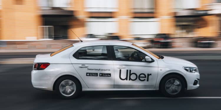 Ukraine, Kyiv - 16 July 2021: White Ford Falcon Taxi Uber car moving on the street. Editorial