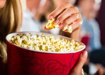 Comendo pipoca com filme — Créditos: depositphotos.com / Kzenon