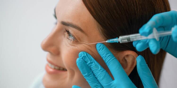 Beauty treatment. A dark-haired mid aged woman having a beaty injections procedure