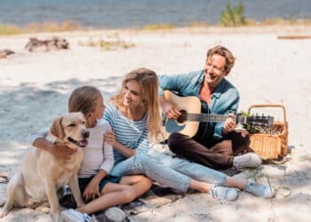 Família curtindo as férias na praia com cachorro - Créditos: depositphotos.com / HayDmitriy