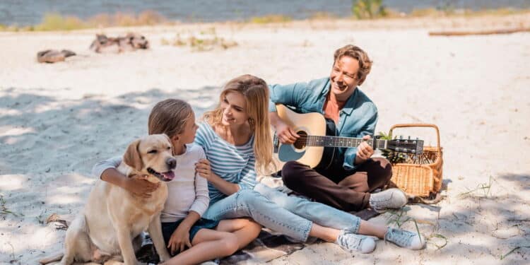 Família curtindo as férias na praia com cachorro - Créditos: depositphotos.com / HayDmitriy