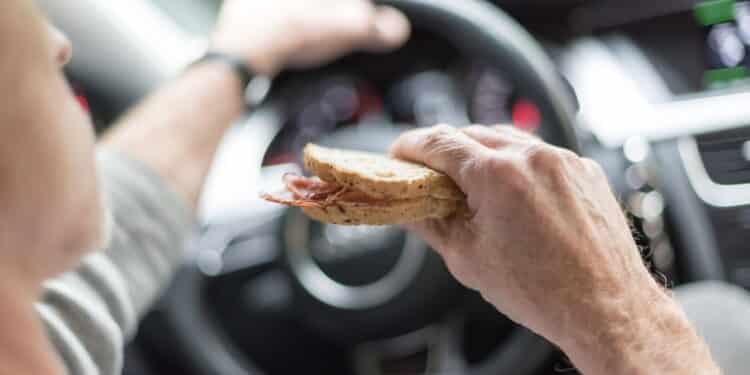 Motorista comendo ao volante - Créditos: depositphotos.com / thodonal