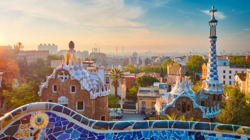 Vista da cidade de Barcelona a partir do Parque Guell com edifícios de mosaicos coloridos na atração turística Parque Guell pela manhã ao nascer do sol.